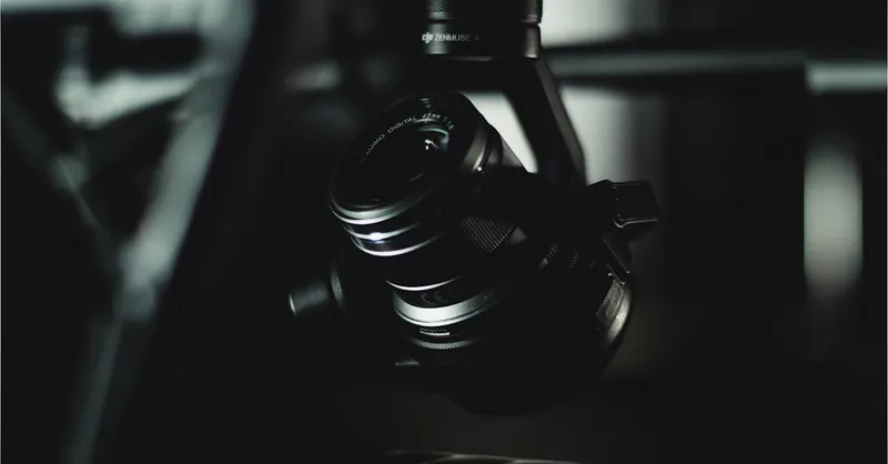 Detailed close-up of a camera lens mounted on a gimbal, in low light.