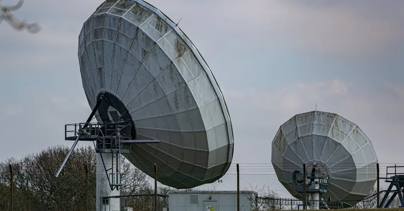 Two large radio telescopes in an outdoor setting, showcasing astronomy and science technology.