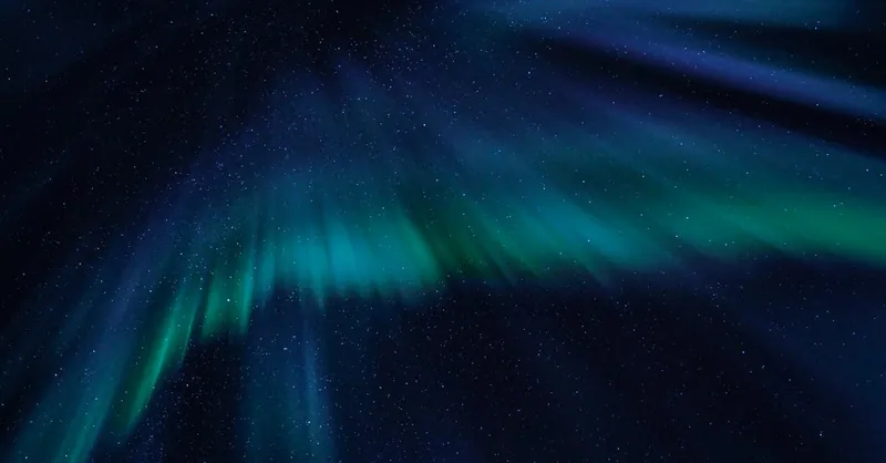Breathtaking view of the aurora borealis illuminating the starry night sky with vibrant green and blue hues.