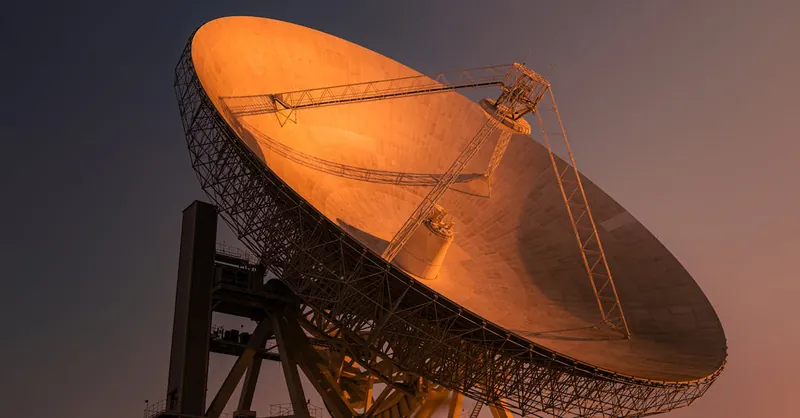 A striking satellite dish basking in golden hour light, capturing signals from space.