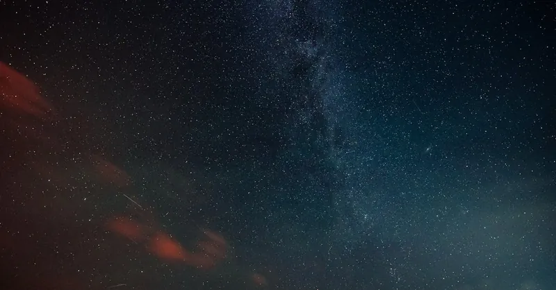 Vibrant night sky featuring the Milky Way and countless stars above the horizon.