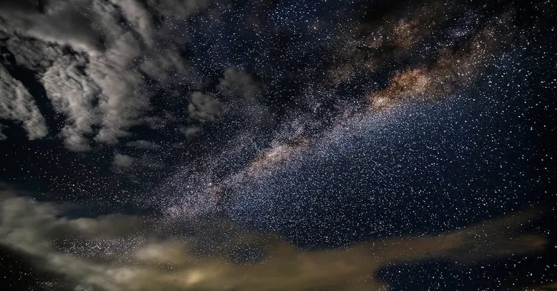 A breathtaking photo capturing the Milky Way galaxy with stars and clouds in a dark, starry sky.