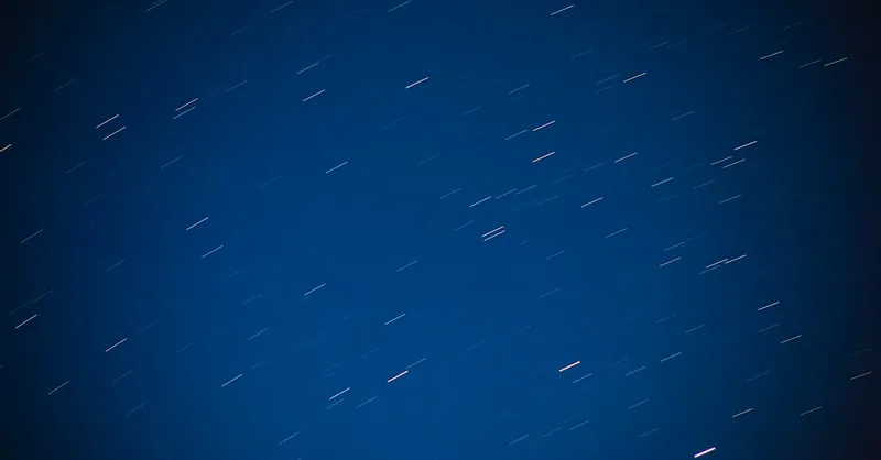 Captivating long exposure of star trails against a deep blue night sky, highlighting cosmic motion.