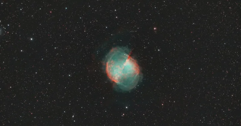 Vibrant image of the Dumbbell Nebula amidst starry cosmos, showcasing celestial beauty.
