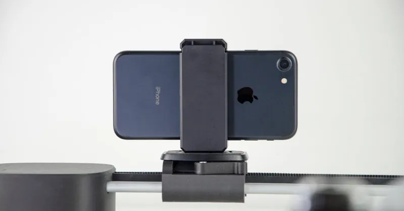 A close-up image of a smartphone mounted on a slider, ideal for video production and cinematic capturing.