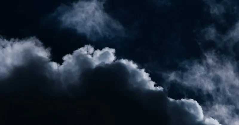 Moody dark clouds forming in a night sky, evoking mystery and depth.