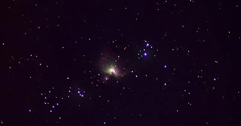 Vivid capture of the Orion Nebula amidst a star-filled night sky, showcasing cosmic beauty.