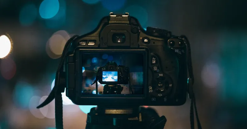 Close-up of a DSLR camera capturing a bokeh background in a dimly lit setting, illustrating night photography.