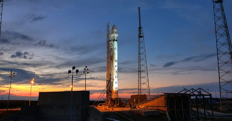 Solid rocket installed on metal launch construction in spaceport and ready for taking off against colorful sunset sky