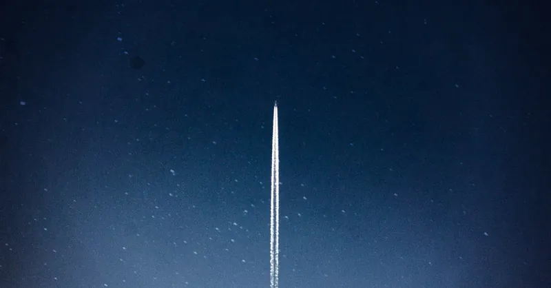A rocket streaks through a starry night, leaving a trail in outer space.
