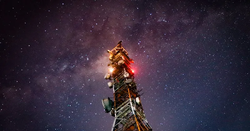 Night shot of a communication tower against a starry sky, showcasing connectivity and the cosmos.
