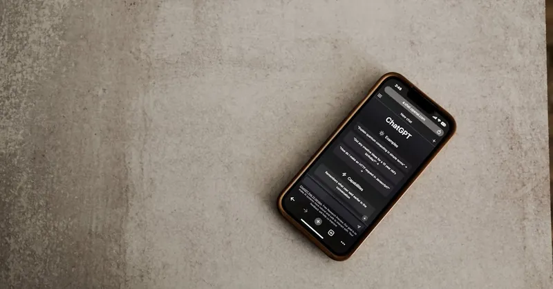 Close-up of a smartphone with the ChatGPT app open, highlighting AI technology on a textured surface.