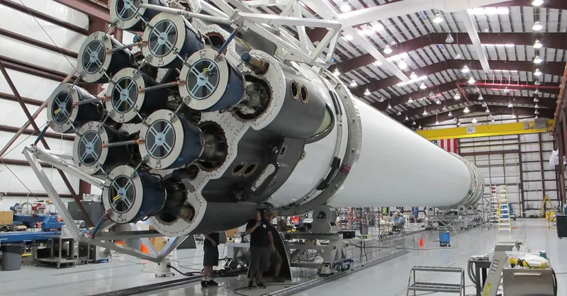 Detailed view of a spacecraft being assembled in an industrial hangar.