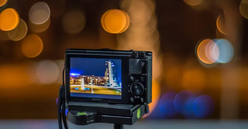Photograph of a DSLR capturing a cityscape at night with a beautiful bokeh background.